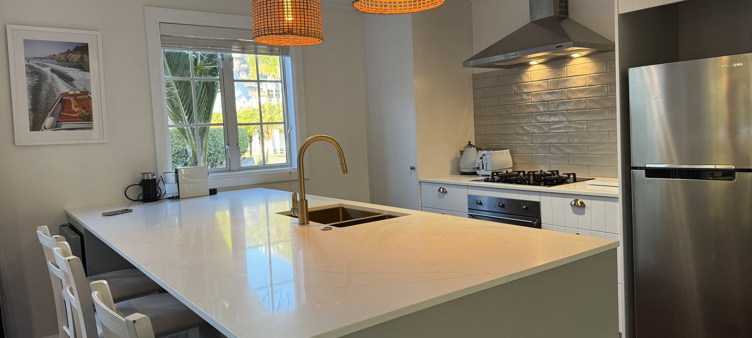 New kitchen with wine fridge, island and breakfast bar at Crab Shack Cottage, a premium holiday home within Russell Cottages