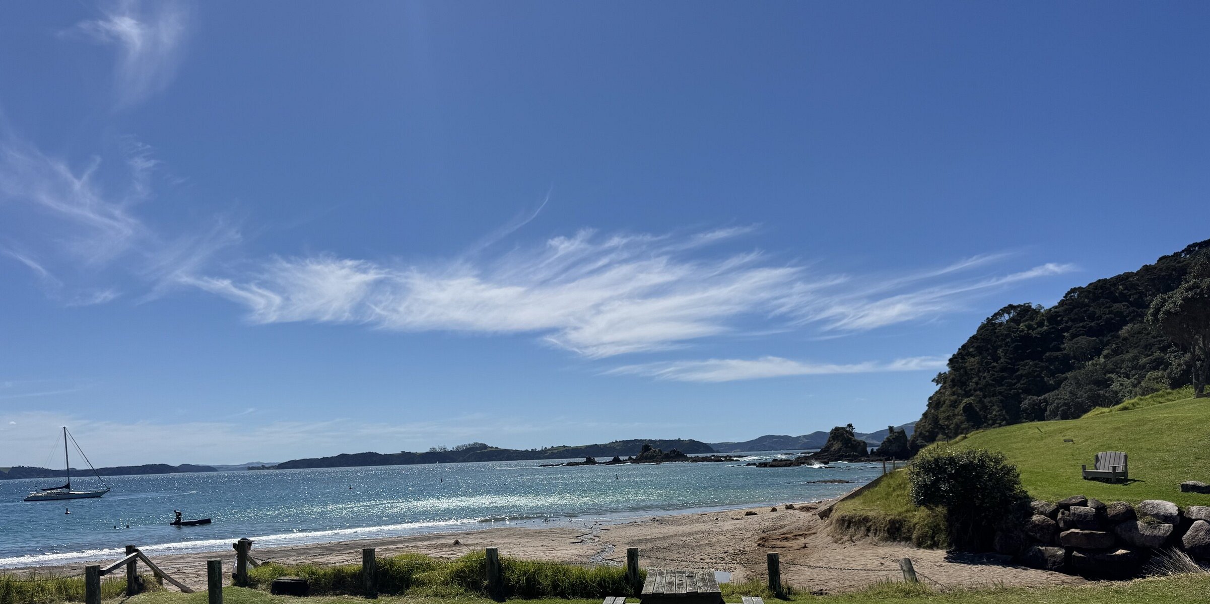 Scenic view of Tapeka Point Beach near Russell, showing the sandy shoreline accessed via a short car drive or a coastal walking track through native bush
