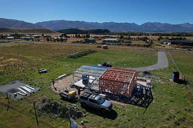 Aerial of the Twizel build with the steel portal frame and timber framing up on the slab, and the Mackenzie mountains all around
