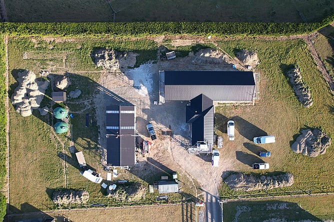 Top-down aerial of the main house and the Twizel minor dwelling with their roofs on, set along the shelterbelt hedge