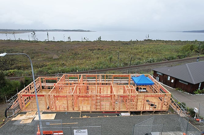 Aerial of the timber wall framing standing on the piled floor, looking out over Lake Brunner