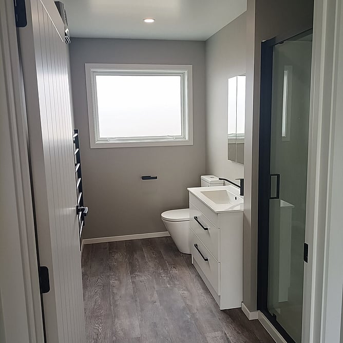 Bathroom with black tapware, a sliding barn door and a glass shower