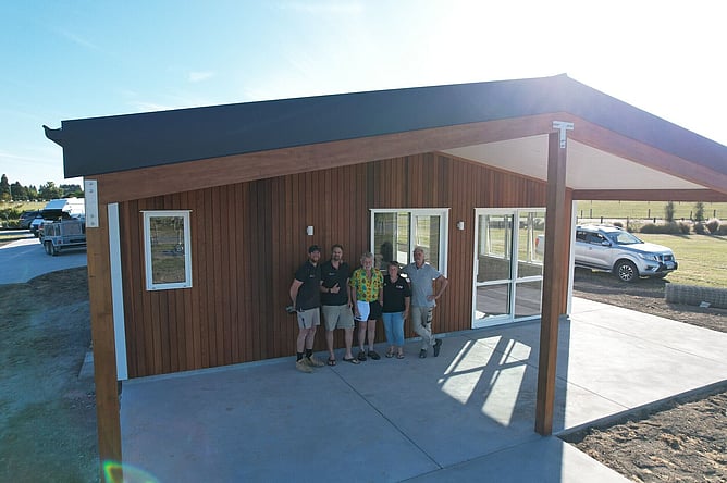 The Lifestyle Builds team with the clients under the finished cedar-lined outdoor living area