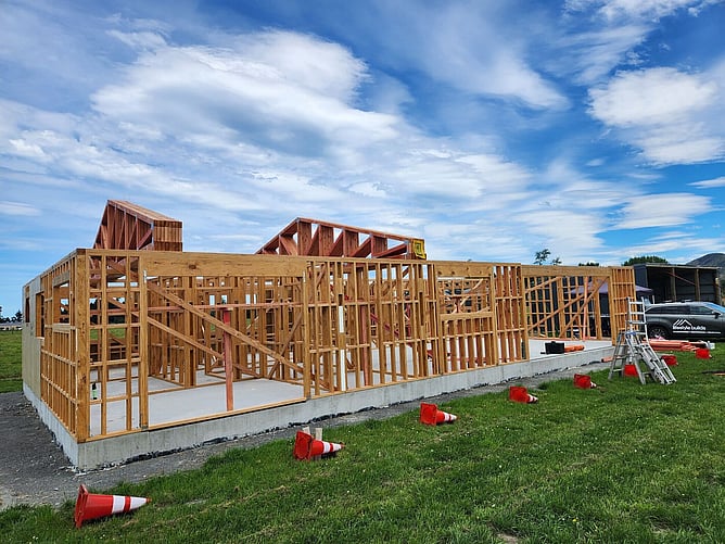 Full timber framing and trusses standing on the slab during the Kaikoura build, with the Lifestyle Builds ute behind