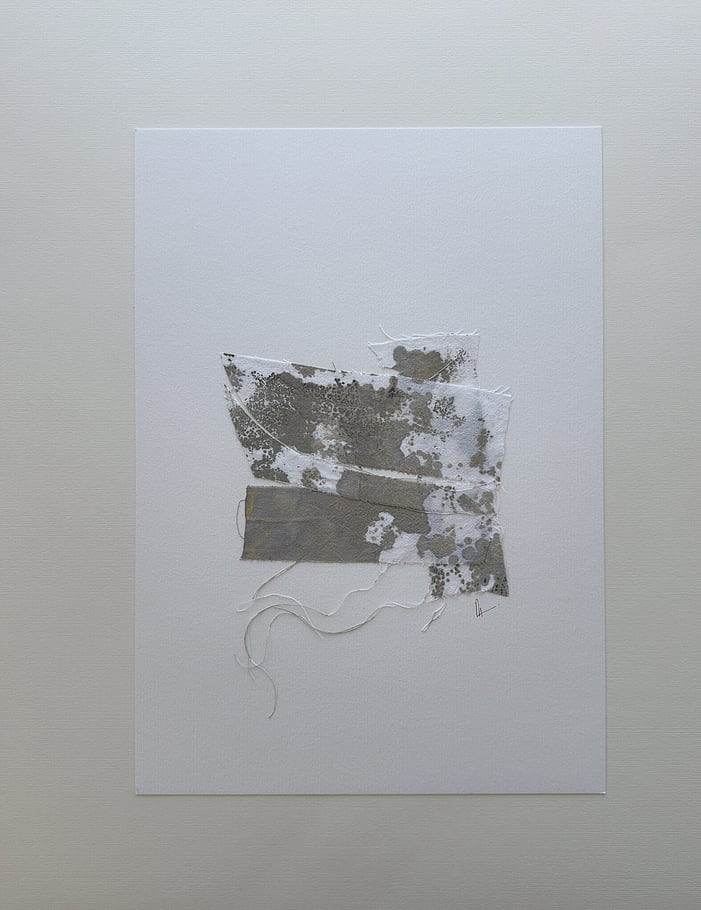 full image of a layered collage on soft white fabriano, showing repurposed pale cream cotton fragments blotted with green-grey and black acrylic, visible weave texture, soft frayed edges and handwritten signature directly beneath the artwork