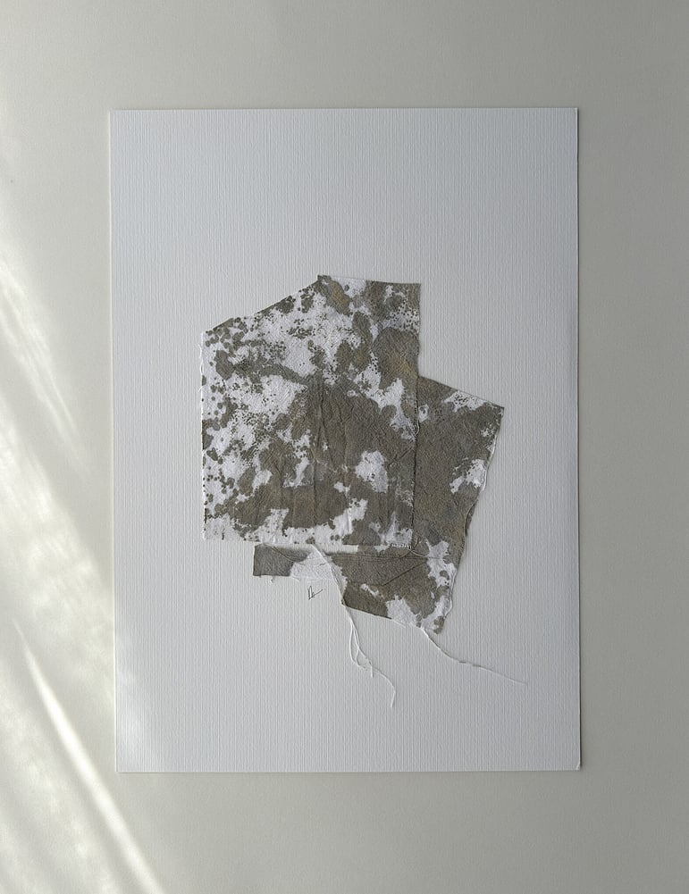 full image of a layered collage on soft white fabriano, showing repurposed pale oat-toned cotton fragments hand-painted with green-grey and raw sienna acrylic, visible weave texture, hanging threads, soft frayed edges and handwritten signature directly beneath the artwork