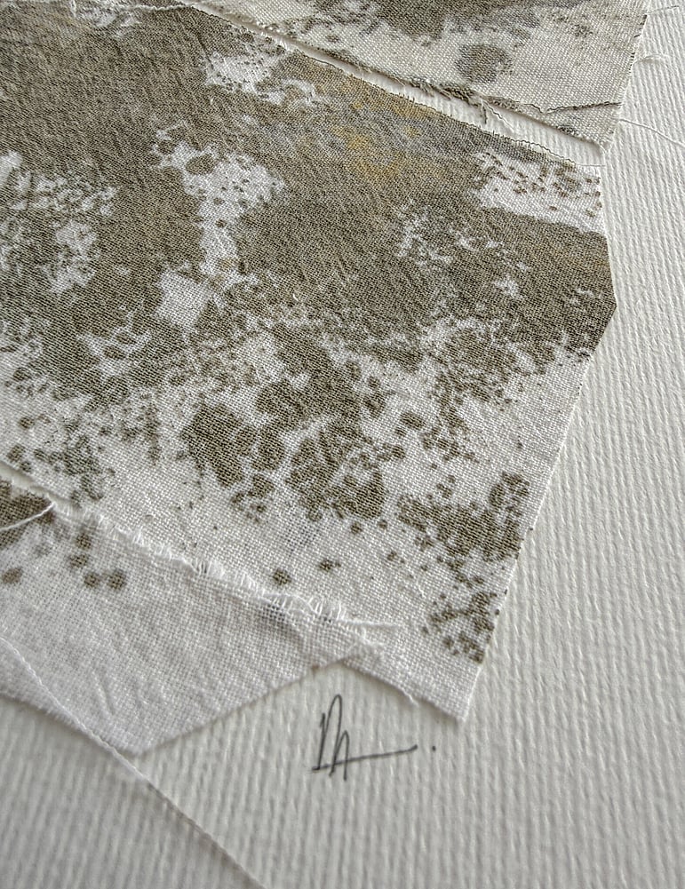 close-up image of soft white fabriano surface texture, layered repurposed pale oat-toned cotton fragments hand-painted with green-grey and raw sienna acrylic, visible weave texture, hanging threads, soft frayed edges and handwritten signature directly beneath the artwork