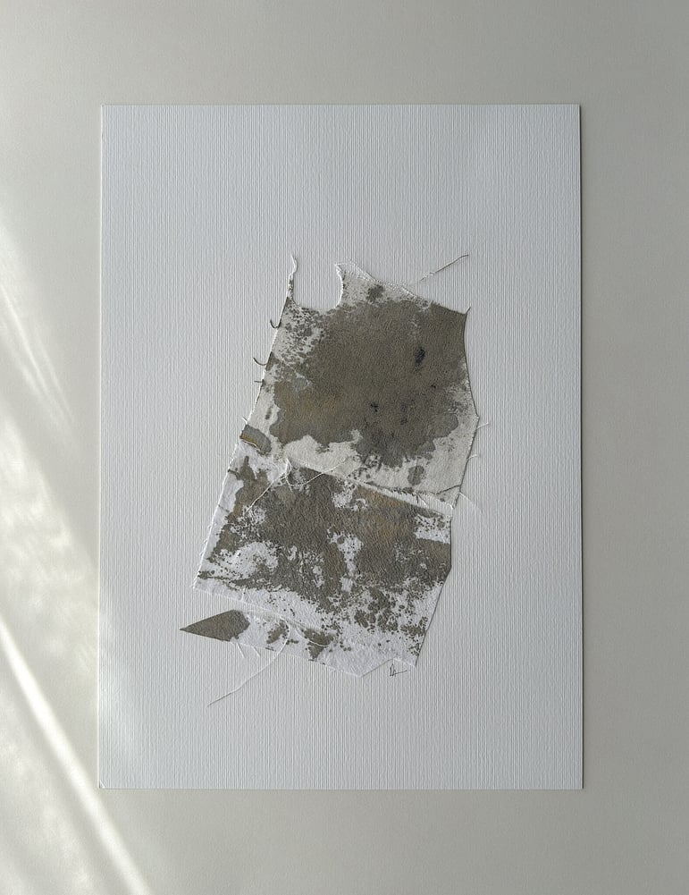 full image of a layered collage on soft white fabriano, showing repurposed pale oat-toned cotton fragments hand-painted with green-grey, raw sienna and black acrylic, visible weave texture, hanging threads, soft frayed edges and handwritten signature directly beneath the artwork