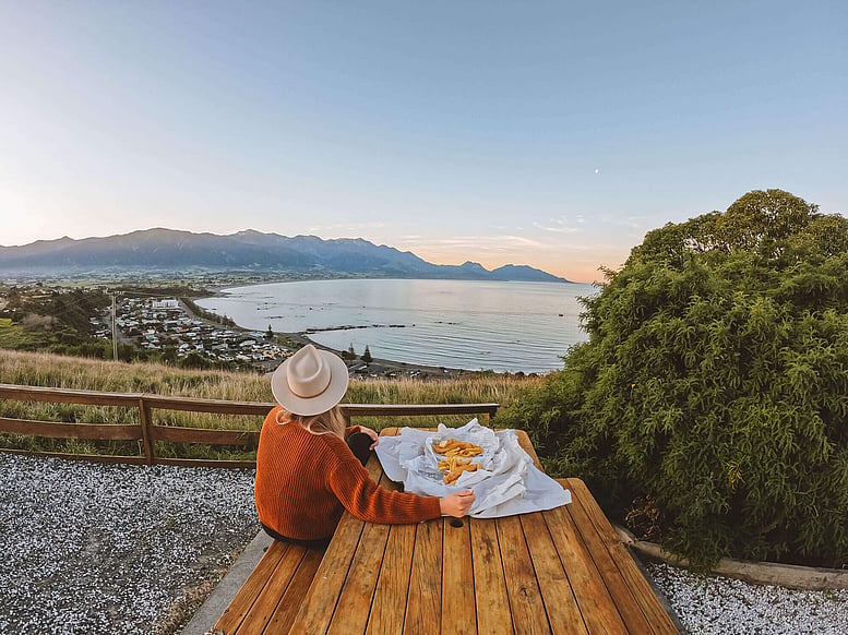 Tourist eating fish and chips at the Kaikoura lookout